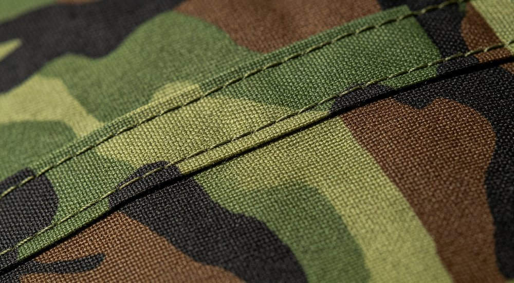 Quality control inspector checking tent fabric and construction, professional quality assurance for humanitarian shelter manufacturing, industrial photography for humanitarian relief shelter procurement with professional quality standards