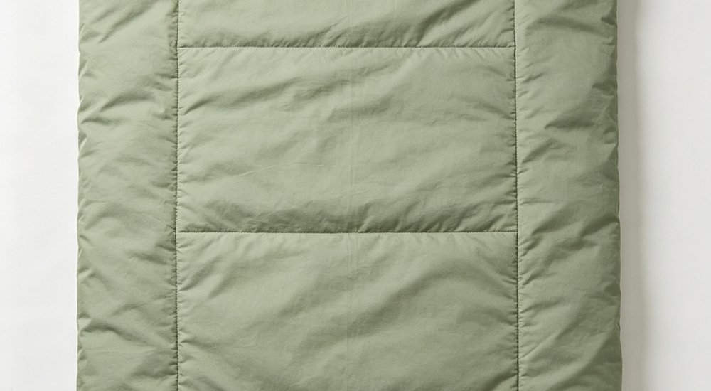 Top down flat lay view of envelope style sleeping bag fully opened flat as blanket showing rectangular shape and full length two way zipper design for versatile institutional use