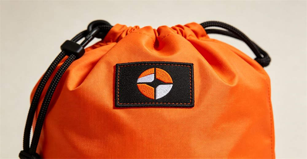 Close-up of custom logo embroidery on orange rescue throw bag showing OEM customization service and thread detail for reliable water rescue operations and emergency response