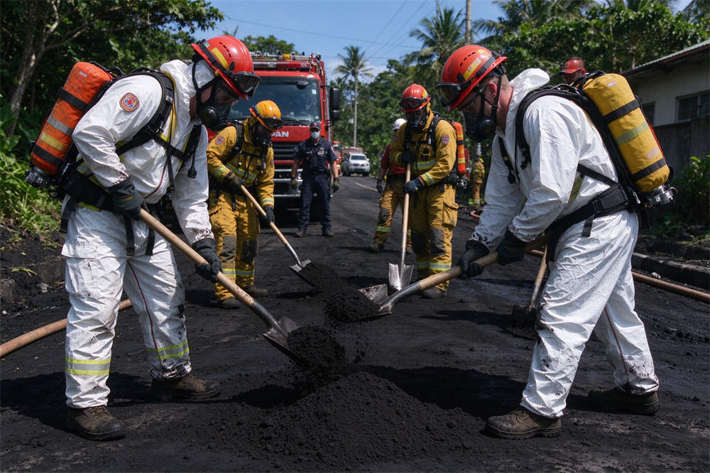 Rescue crew in PPE cleaning volcanic ash from roads, volcano emergency response and relief operations Rescue crew in PPE cleaning volcanic ash from roads, volcano emergency response and relief operations